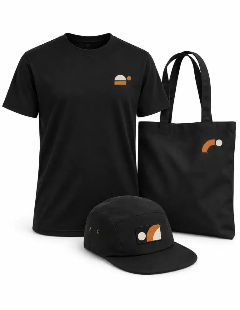 Black T-shirt, cotton bag and cap with small orange and white geometric designs, textile printing examples